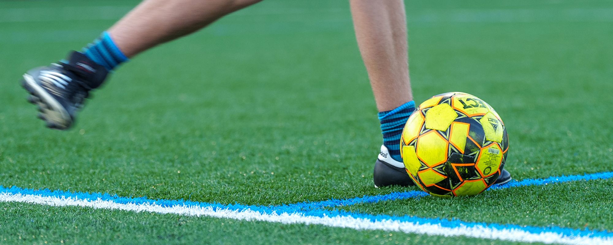 Student kicking a soccer ball